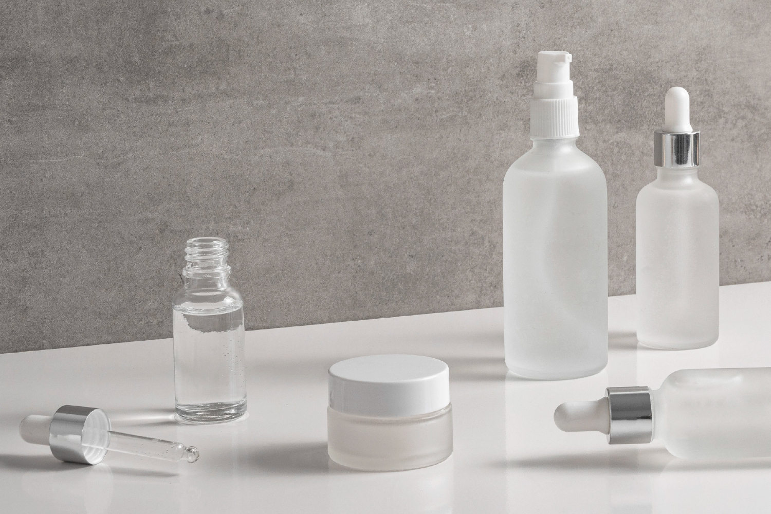 ockup of customized medical-grade skincare bottles and jars for OEM/ODM formulation services.