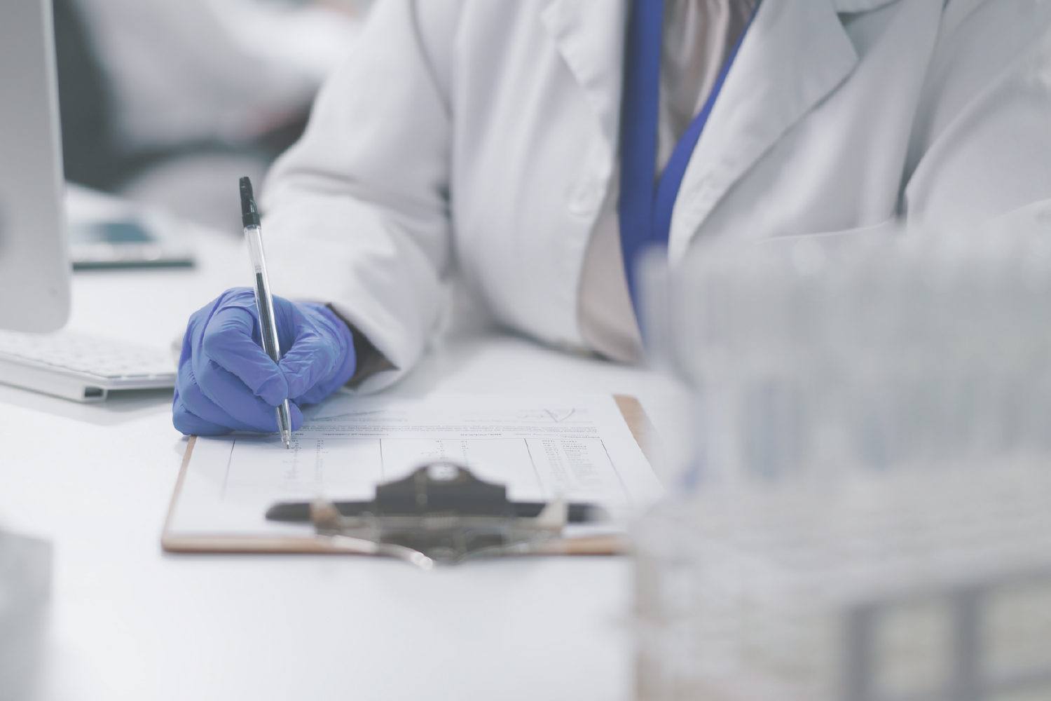 Lab technician wearing gloves and filling quality assurance form