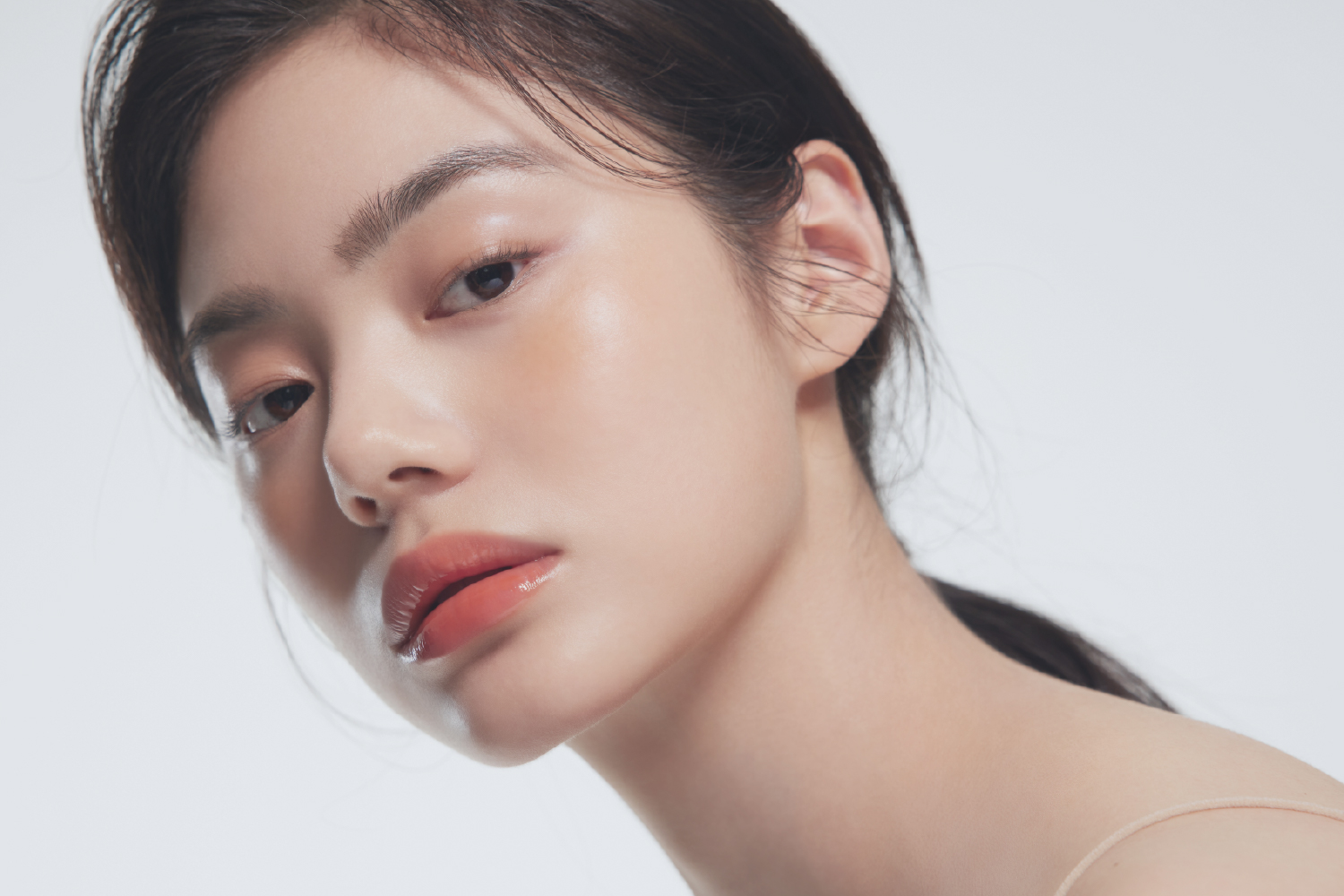 Asian woman with flawless makeup and long lashes, showcasing professional-grade lash beauty results.