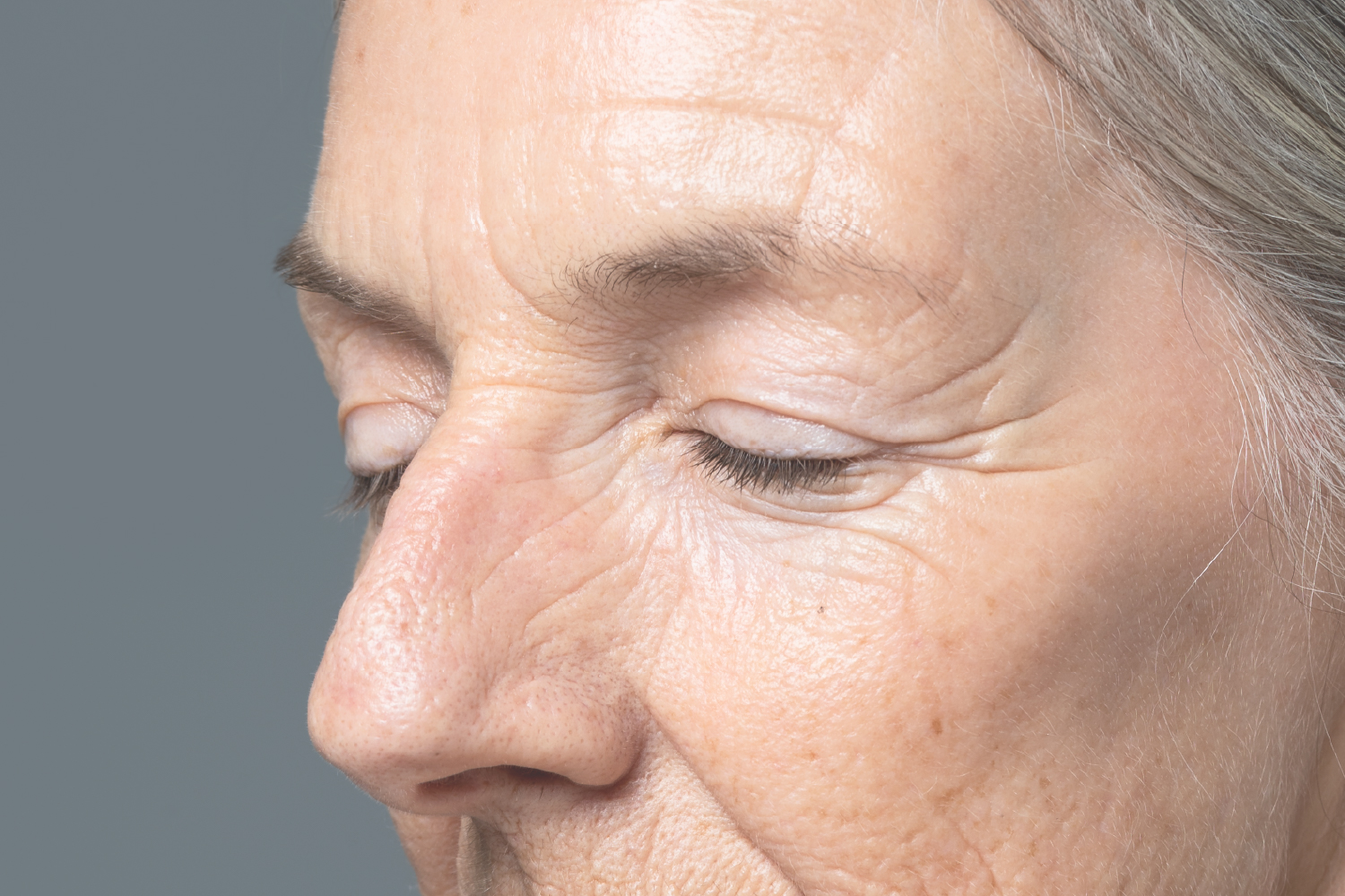 Close-up of mature woman's face with visible fine lines, illustrating targeted skincare efficacy.