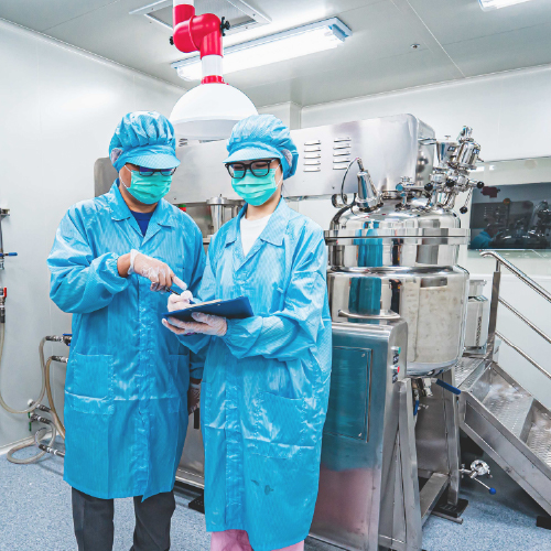 Manufacturing personnel monitoring cosmetic production processes in a GMP-compliant environment